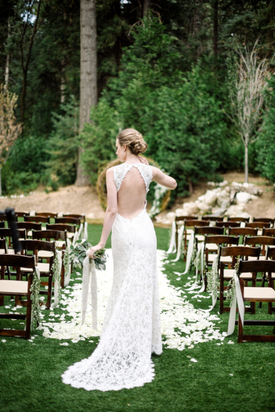 Bride to be in backless wedding gown on a clear day.